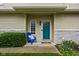 Welcoming front entrance featuring a vibrant turquoise door, a cozy blue chair, and charming decorative accents at 1032 Grovewood Dr # 0, Beech Grove, IN 46107