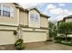 Exterior of a townhome with a two-car garage, adorned with flowers and complemented by a neatly maintained landscape at 1032 Grovewood Dr # 0, Beech Grove, IN 46107