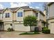 Inviting exterior view of a townhome with a two-car garage, accented by a small tree and manicured landscaping at 1032 Grovewood Dr # 0, Beech Grove, IN 46107