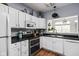Modern kitchen with white cabinets, stainless steel appliances, and stylish backsplash tiles at 1032 Grovewood Dr # 0, Beech Grove, IN 46107