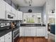 Well-lit kitchen with stainless steel appliances, white cabinets, and view to outdoor greenery at 1032 Grovewood Dr # 0, Beech Grove, IN 46107