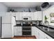 Modern kitchen with white cabinets, stainless steel appliances, and sleek black countertops at 1032 Grovewood Dr # 0, Beech Grove, IN 46107