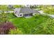 Aerial view of the home's large backyard features a manicured lawn, screened in patio and mature trees at 10794 Pine Needle Ct, Fishers, IN 46037