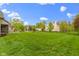Expansive backyard with lush green grass and mature trees provides ample space for outdoor activities and recreation at 10794 Pine Needle Ct, Fishers, IN 46037