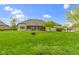 Expansive backyard with lush lawn, tree, fire pit, and partial view of a screened in patio, ideal for outdoor activities at 10794 Pine Needle Ct, Fishers, IN 46037