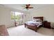 Serene bedroom with a ceiling fan, large windows, and comfortable carpet at 10794 Pine Needle Ct, Fishers, IN 46037