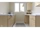 Bright laundry room with lots of cabinet space, sink, and nice view from window at 10794 Pine Needle Ct, Fishers, IN 46037