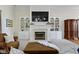 Living room featuring a fireplace with TV, built-in shelving, neutral carpet, and leather furniture at 10794 Pine Needle Ct, Fishers, IN 46037