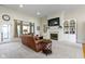 Living room featuring a fireplace with a TV, neutral carpet, and natural lighting through the window at 10794 Pine Needle Ct, Fishers, IN 46037