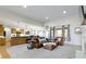 Open-concept living room features a leather sofa set, neutral carpet, and an open view into the kitchen at 10794 Pine Needle Ct, Fishers, IN 46037