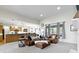 Bright living room with neutral carpet and a leather sofa set, open to kitchen and dining area at 10794 Pine Needle Ct, Fishers, IN 46037