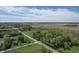 Expansive aerial view of a property featuring lush greenery, open fields, and a tranquil, tree-lined road at 10912 N County Road 950 E, Brownsburg, IN 46112