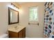 Bathroom features a spacious vanity with an undermount sink, decorative mirror, lighting fixture, and a shower-tub combo at 10912 N County Road 950 E, Brownsburg, IN 46112