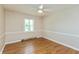 Large bedroom boasts hardwood floors, neutral paint, a ceiling fan, and a large window offering ample natural light at 10912 N County Road 950 E, Brownsburg, IN 46112