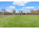 Expansive backyard featuring a lush lawn, garden beds, and neighboring residential buildings at 120 Crosby Dr, Indianapolis, IN 46227