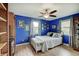 Comfortable bedroom featuring hardwood floors, ceiling fan, and bright blue walls at 120 Crosby Dr, Indianapolis, IN 46227