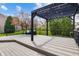 Backyard deck featuring a modern black pergola, comfortable furniture, and a manicured yard at 12011 Glen Cove Dr, Indianapolis, IN 46236