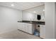 Basement kitchenette featuring a large mirror, counter with sink, and white cabinets at 12011 Glen Cove Dr, Indianapolis, IN 46236