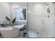 Bright bathroom features a modern shower with glass door, marble floors, and a standalone tub at 12011 Glen Cove Dr, Indianapolis, IN 46236