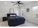 Well-lit bedroom featuring a dark bed frame, two windows, and wall art at 12011 Glen Cove Dr, Indianapolis, IN 46236