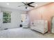 Bright Bedroom with pink accent wall, a ceiling fan, and two windows at 12011 Glen Cove Dr, Indianapolis, IN 46236