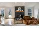Inviting living room featuring refinished hardwood floors and a cozy fireplace with black brick at 12011 Glen Cove Dr, Indianapolis, IN 46236