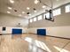 Indoor basketball court featuring hardwood flooring, multiple windows, and ample lighting at 1230 Amberley Way, Westfield, IN 46074