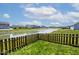 Scenic backyard view featuring a serene pond, well-maintained lawn, and a charming picket fence at 1239 Northcraft Ct, Franklin, IN 46131