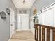 Welcoming entryway with light gray walls, coat racks, wood floors, and a decorative 