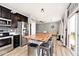 Open kitchen with island seating, stainless steel appliances, dark cabinets and view to living area at 1239 Northcraft Ct, Franklin, IN 46131