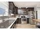 Modern kitchen featuring stainless steel appliances, dark wood cabinets, and a gray tiled backsplash at 1239 Northcraft Ct, Franklin, IN 46131