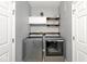 Efficient laundry room with modern washer and dryer, cabinets, shelves, and neutral gray walls at 1239 Northcraft Ct, Franklin, IN 46131