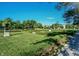 Beautifully landscaped green space featuring manicured lawns, hedges, flower beds, and mature trees under a blue sky at 12725 Parsons Gate, Carmel, IN 46032