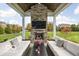 Inviting covered patio with stone fireplace, outdoor sofas, and landscaped backyard views at 12725 Parsons Gate, Carmel, IN 46032