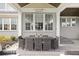 Elegant covered patio features an outdoor dining table, chairs, and exterior brick accent wall at 12725 Parsons Gate, Carmel, IN 46032