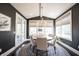 A dining room with six chairs around a wooden table on a patterned rug, brightened by natural light at 12725 Parsons Gate, Carmel, IN 46032
