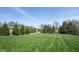 Expansive front yard with mature trees, manicured lawn, and circular driveway leading to a stately home at 12725 Parsons Gate, Carmel, IN 46032