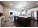 View of the kitchen island with seating, stainless refrigerator and view to the Gathering room with fireplace at 12725 Parsons Gate, Carmel, IN 46032