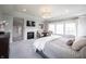 Bright main bedroom showcasing a fireplace, sitting area, neutral walls, and a large bed at 12725 Parsons Gate, Carmel, IN 46032
