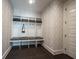 Mudroom with built-in storage, seating, and hooks, plus decorative wallpaper and a dark floor at 12725 Parsons Gate, Carmel, IN 46032
