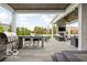 Covered outdoor kitchen and patio area with grill, seating, fireplace and lush landscaping at 12725 Parsons Gate, Carmel, IN 46032