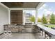 Outdoor kitchen with built-in grill, bar seating, and backyard views, perfect for entertaining at 12725 Parsons Gate, Carmel, IN 46032
