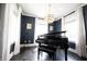 Elegant room featuring a grand piano, stylish lighting, and large windows with curtains at 12725 Parsons Gate, Carmel, IN 46032