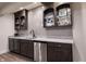 Modern wet bar features granite counters, stainless steel refrigerator and handsome display cabinets at 12725 Parsons Gate, Carmel, IN 46032