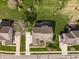 Aerial view of a home with a lush green yard, a driveway, mature trees, and a playset at 16016 Viking Lair Rd, Westfield, IN 46074
