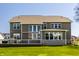 Beautiful back exterior of home featuring large windows, stone accents, and an outdoor deck on a green lawn at 16016 Viking Lair Rd, Westfield, IN 46074
