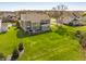 Spacious backyard view showcasing the home, deck, large grassy area, and mature trees at 16016 Viking Lair Rd, Westfield, IN 46074