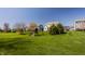 Large, green backyard features playground equipment and mature trees in a Gathering-friendly neighborhood at 16016 Viking Lair Rd, Westfield, IN 46074