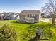 Expansive backyard with a well-maintained lawn, playset, and a view of the home's rear exterior at 16016 Viking Lair Rd, Westfield, IN 46074