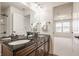 Bathroom with a double sink vanity, dark countertop, and an open doorway to a bedroom at 16016 Viking Lair Rd, Westfield, IN 46074